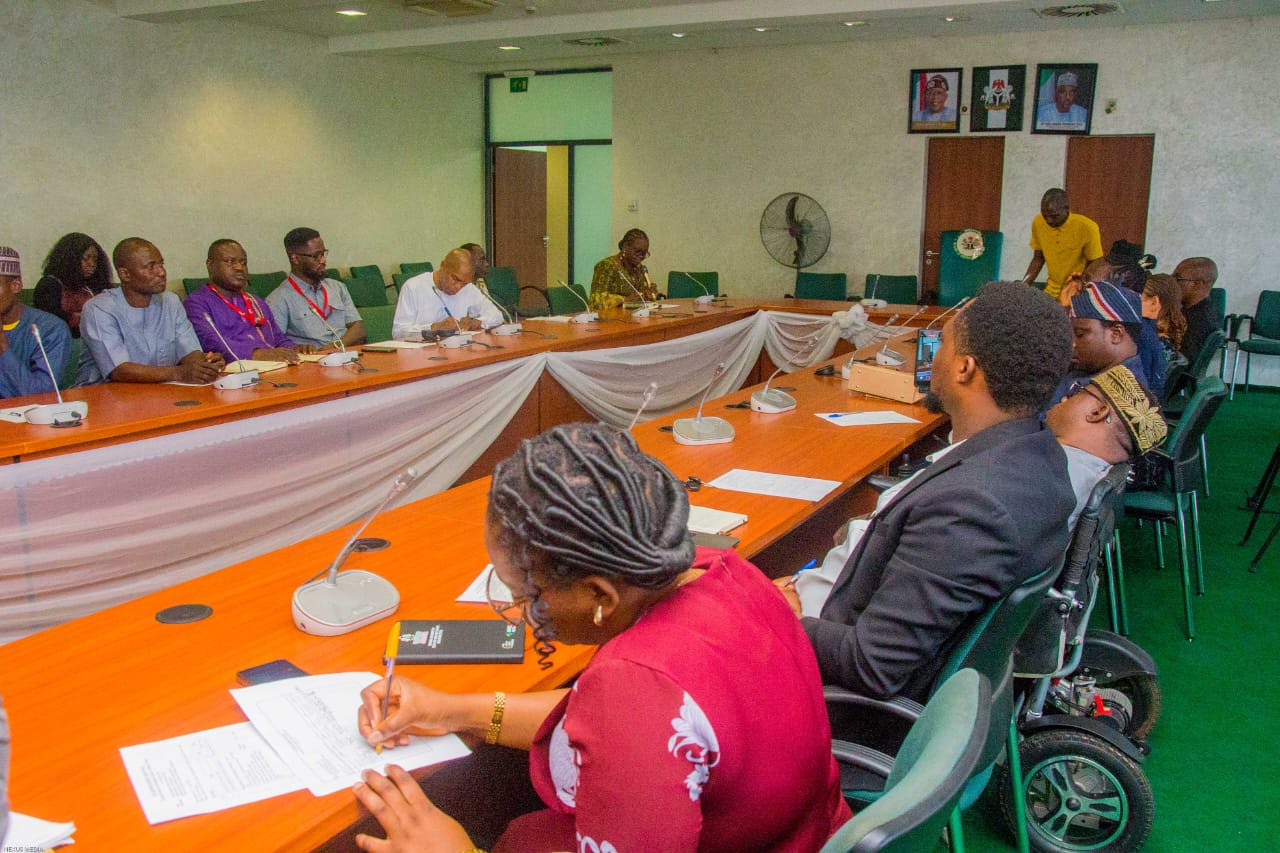 Delegates seated around the committee room table